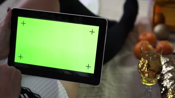 A tablet with an empty green screen in the hands of a woman. Christmas and New year. — Stock Video