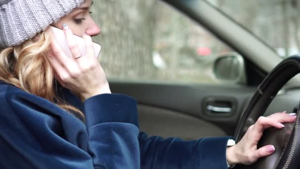 Vintern, en kvinna som pratar på en smartphone i bilen. — Stockvideo