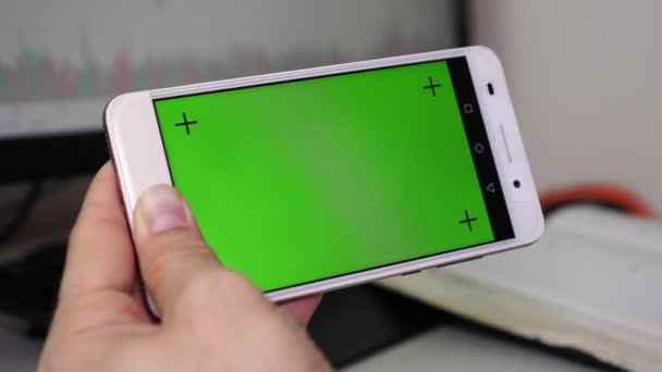 Bir adam bir smartphone ile yeşil bir ekran tutan ve parmağıyla ekran dokunur. — Stok video