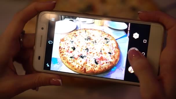 Una donna scatta foto di cibo in un ristorante usando uno smartphone . — Video Stock