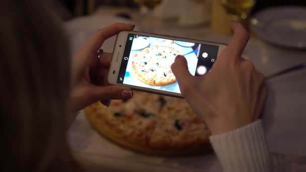 Una donna che usa uno smartphone scatta foto di cibo sul tavolo in un caffè . — Video Stock