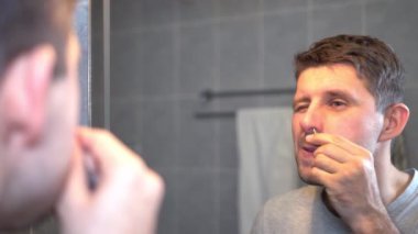 adam tuvalette onun burun kılı cımbızla kendiniyoluyor..