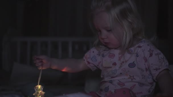 Liten flicka på kvällen med jul leksak. — Stockvideo