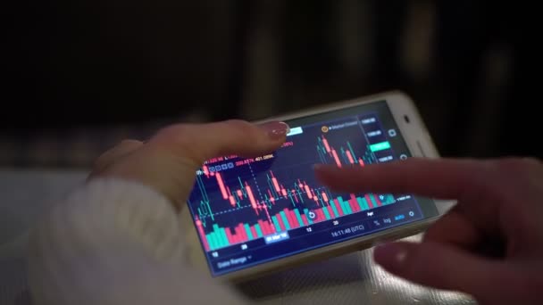 Borsa app üstünde onun smartphone kullanarak bir kadın çalışıyor. — Stok video