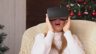 Kadın Noel ağacı arka plan üzerinde sanal gerçeklik bardaklarda.