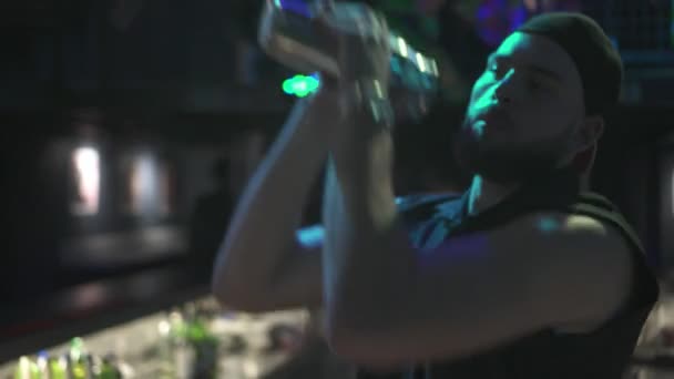 Joyful bartender blandar en cocktail i en shaker — Stockvideo