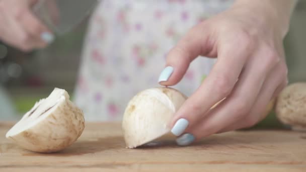 Frau schneidet Pilze auf Holzbrett — Stockvideo