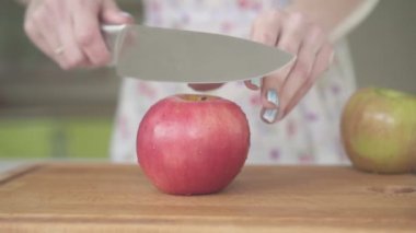 Kadın mutfakta bir elma cuts.