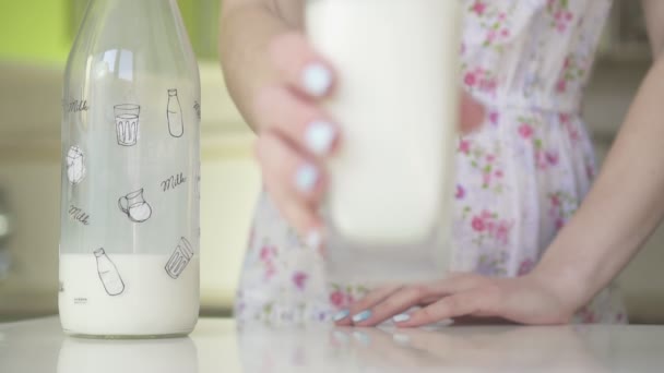 Frau legt ein Glas Milch auf den Tisch, Zeitlupe. — Stockvideo