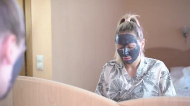 Yüz cilt bakımı. Bir kadın evde bir kuyruklu yıldız maske yüzünde koyar..