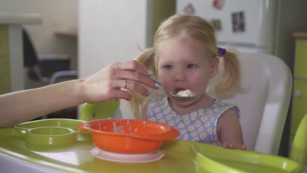 台所でお粥を食べる小さな女の赤ちゃん — ストック動画