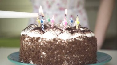 Kadın ışıklar mum bir Doğum günü pastası.