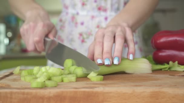 Mulher na cozinha cortando aipo . — Vídeo de Stock