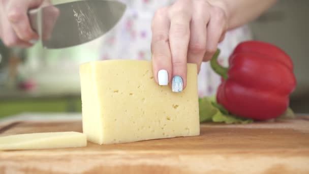 Mulher cortando queijo na cozinha — Vídeo de Stock