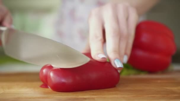 Mujer en la cocina cortando pimiento rojo, pimentón . — Vídeo de stock