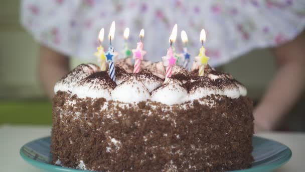 Mulher soprando velas em um bolo de aniversário. — Vídeo de Stock