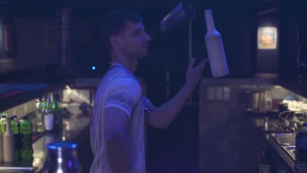 Un camarero profesional hace malabares con botellas en un club nocturno . — Vídeos de Stock