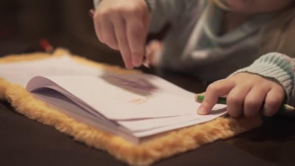 Una niña pequeña dibuja con un lápiz . — Vídeos de Stock