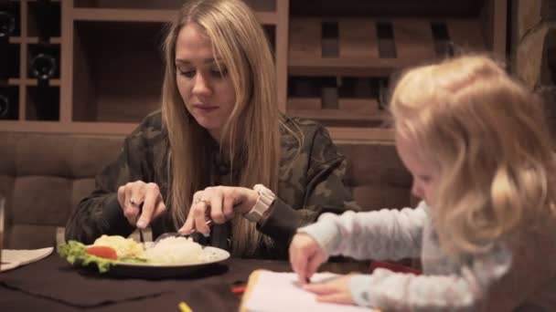 Eine Frau und ein kleines Kind in einem Café. — Stockvideo