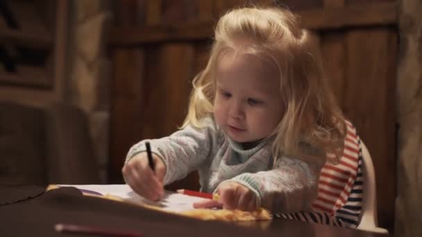 Klein meisje kind trekt met een potlood. — Stockvideo