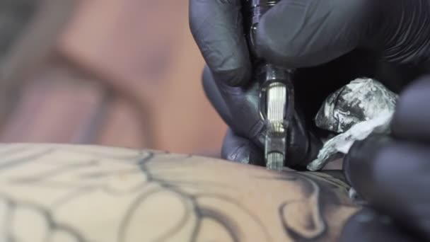 Maestro tatuador en el trabajo, primer plano. Estudio de tatuaje . — Vídeos de Stock