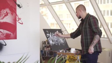 Genç modern ressam boyalar bir sanat atölyesinde resim.