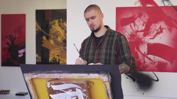 Портрет молодого художника в творческой мастерской . — стоковое видео