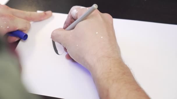 Καλλιτέχνης κάνει ένα σκίτσο σε ένα φύλλο χαρτιού. — Αρχείο Βίντεο