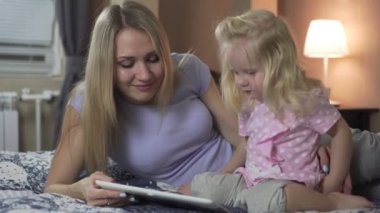 Mutlu aile, anne ve kızı evde tablet kullanmanın keyfini çıkarın.