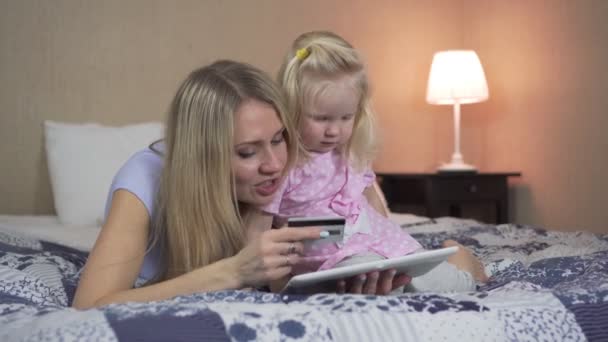 Uma mulher explica ao filho como usar um cartão bancário . — Vídeo de Stock