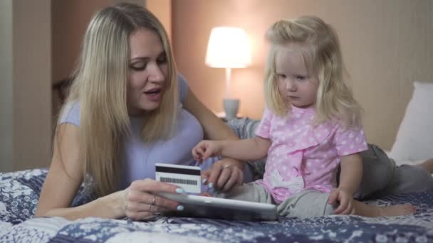 Mamma lär sitt barn att göra onlineköp med kreditkort. — Stockvideo