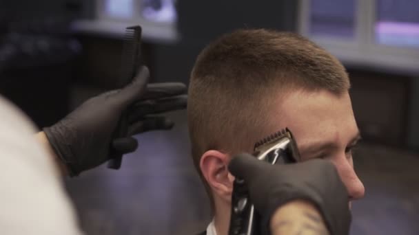 Slow motion barber maaien client met een klipper in een kapsalon. — Stockvideo