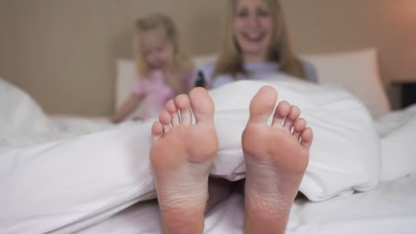 Mamma e figlia stanno guardando la TV la sera in camera da letto . — Video Stock