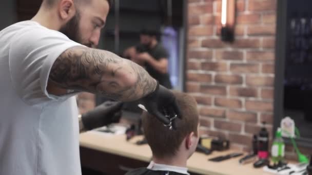 Мужчина разрезает в современной парикмахерской . — стоковое видео