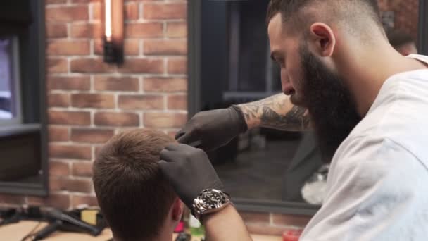 Портрет сучасного чоловіка-перукаря з бородою при роботі в перукарні . — стокове відео