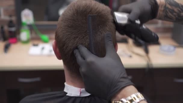 Il barbiere taglia il cliente con un tagliacapelli, primo piano . — Video Stock