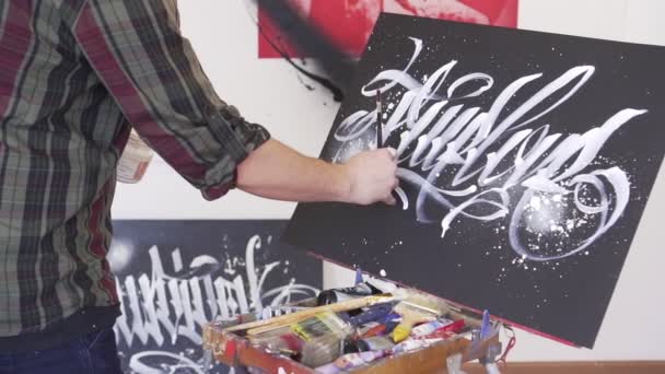 Un homme artiste dessine un tableau sur le chevalet . — Video