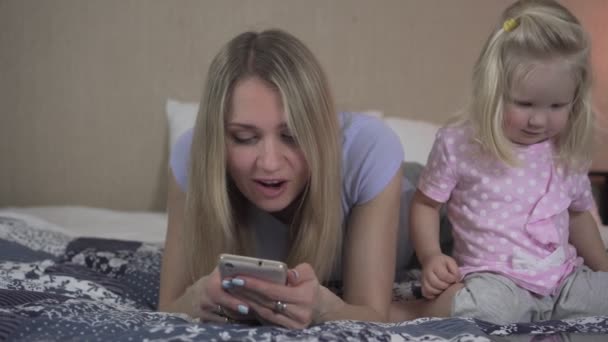 Familia feliz usando su dispositivo en casa. Mujer y niño con smartphone y tablet . — Vídeos de Stock