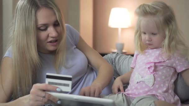 Una familia feliz en casa utiliza un banco o tarjeta de crédito . — Vídeos de Stock