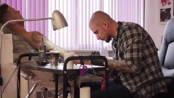 Homme tatoueur fait le client un tatouage dans le salon, au ralenti . — Video