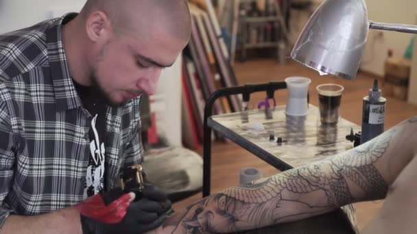 Retrato de um tatuador enquanto trabalhava, câmera lenta . — Vídeo de Stock
