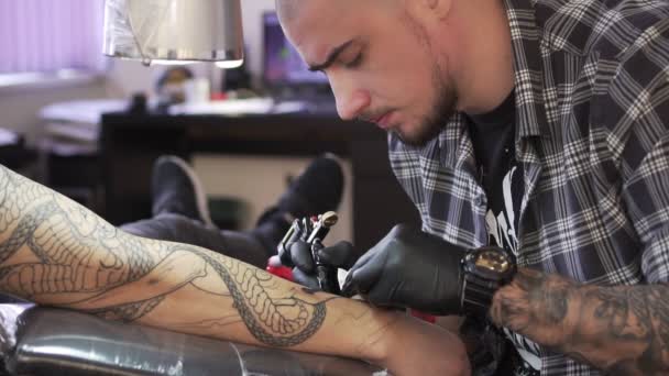 Tattoo master draws a tattoo on the mans hand — Stock Video