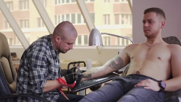 En mand laver en tatovering i en tatovør . – Stock-video