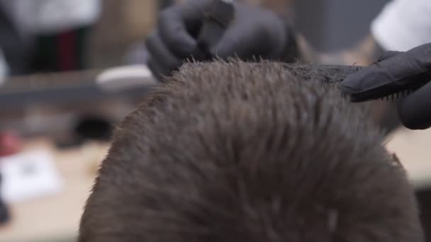 Un hombre es cortado en una barbería de moda. Hombre cortado con una navaja de afeitar, primer plano . — Vídeos de Stock