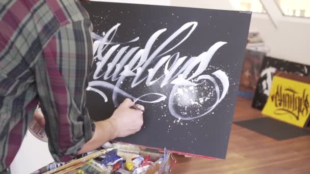 Muž umělec kreslí obraz na malířském stojanu. — Stock video