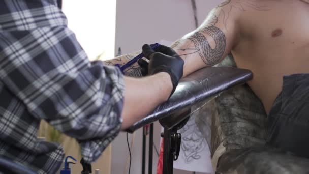 Mestre de tatuagem faz a barba de uma mão de clientes antes da tatuagem . — Vídeo de Stock