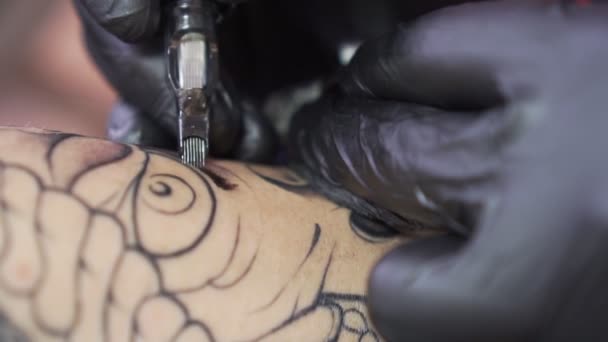 Proceso de tatuaje de cerca. La aguja de la máquina de tatuaje inserta tinta debajo de la piel . — Vídeo de stock