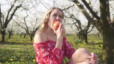 Bahar, genç kadın doğada bir elma yiyor.