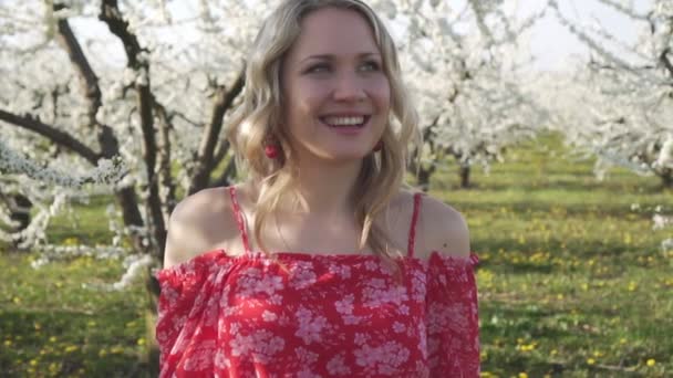 Joven hermosa mujer caminando en el jardín floreciente de primavera . — Vídeos de Stock