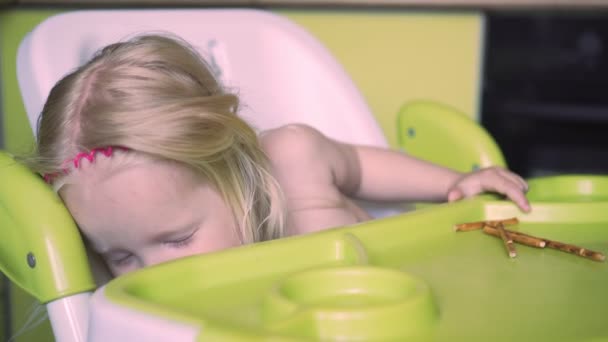 Niño duerme en la mesa de los niños en la cocina . — Vídeos de Stock